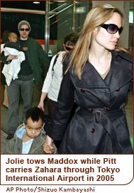 Jolie tows Maddox while Pitt carries Zahara through Tokyo International Airport in 2005