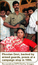 Phoolan Devi, backed by armed guards and supporters, poses at a campaign stop in 1996.